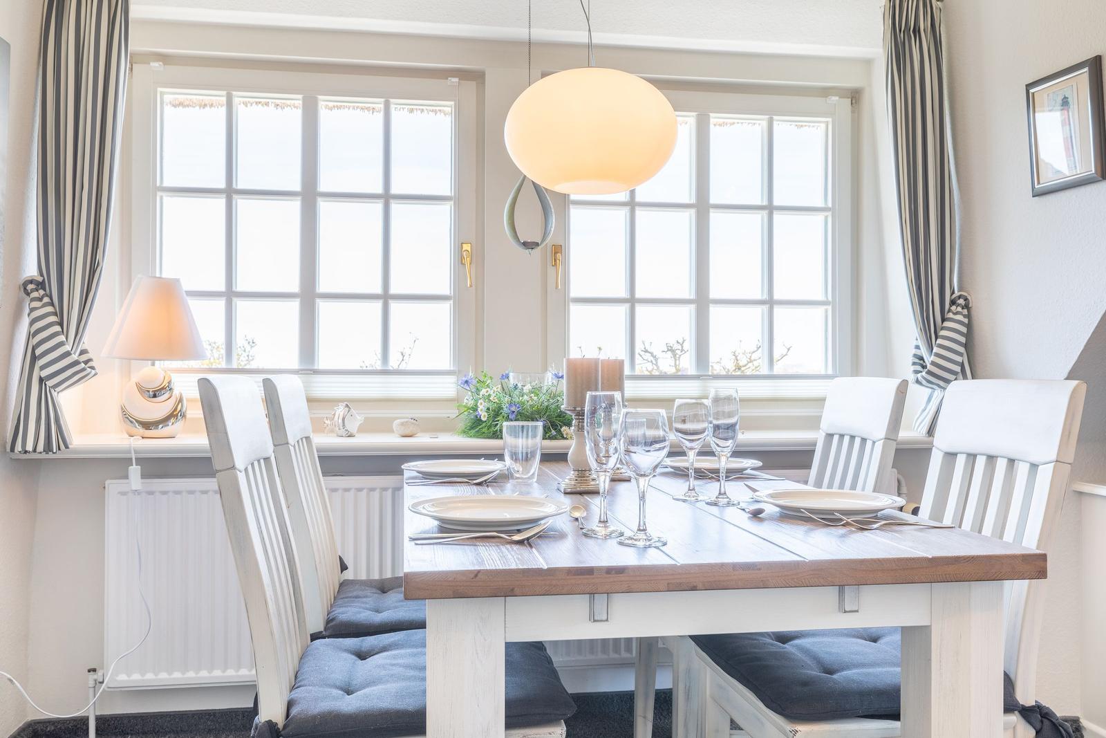 Esszimmer mit Tisch, Stühlen und Fenstern