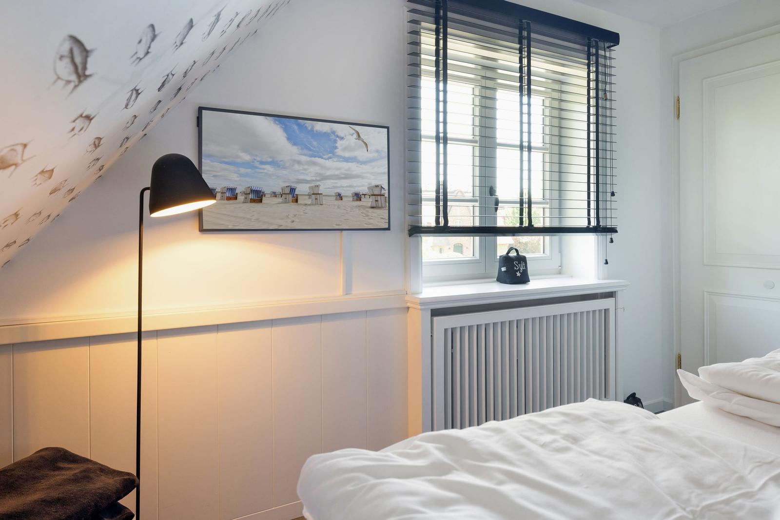 Schlafzimmer mit Dachschräge, Fenster und Bett