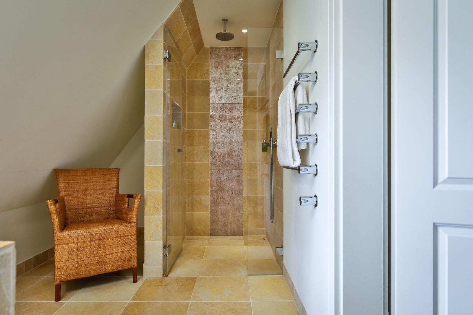 Dusche mit Glaswand, Handtuchhalter und Sitzgelegenheit