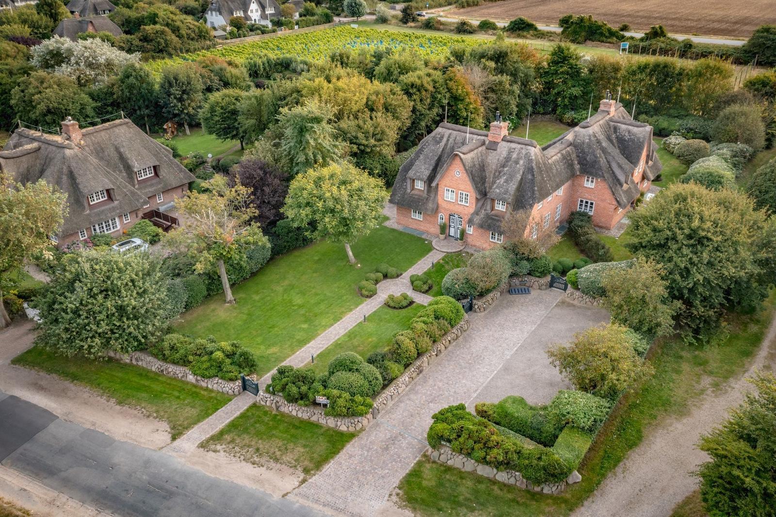 Haus mit Strohdach, gepflegter Garten und Steinweg