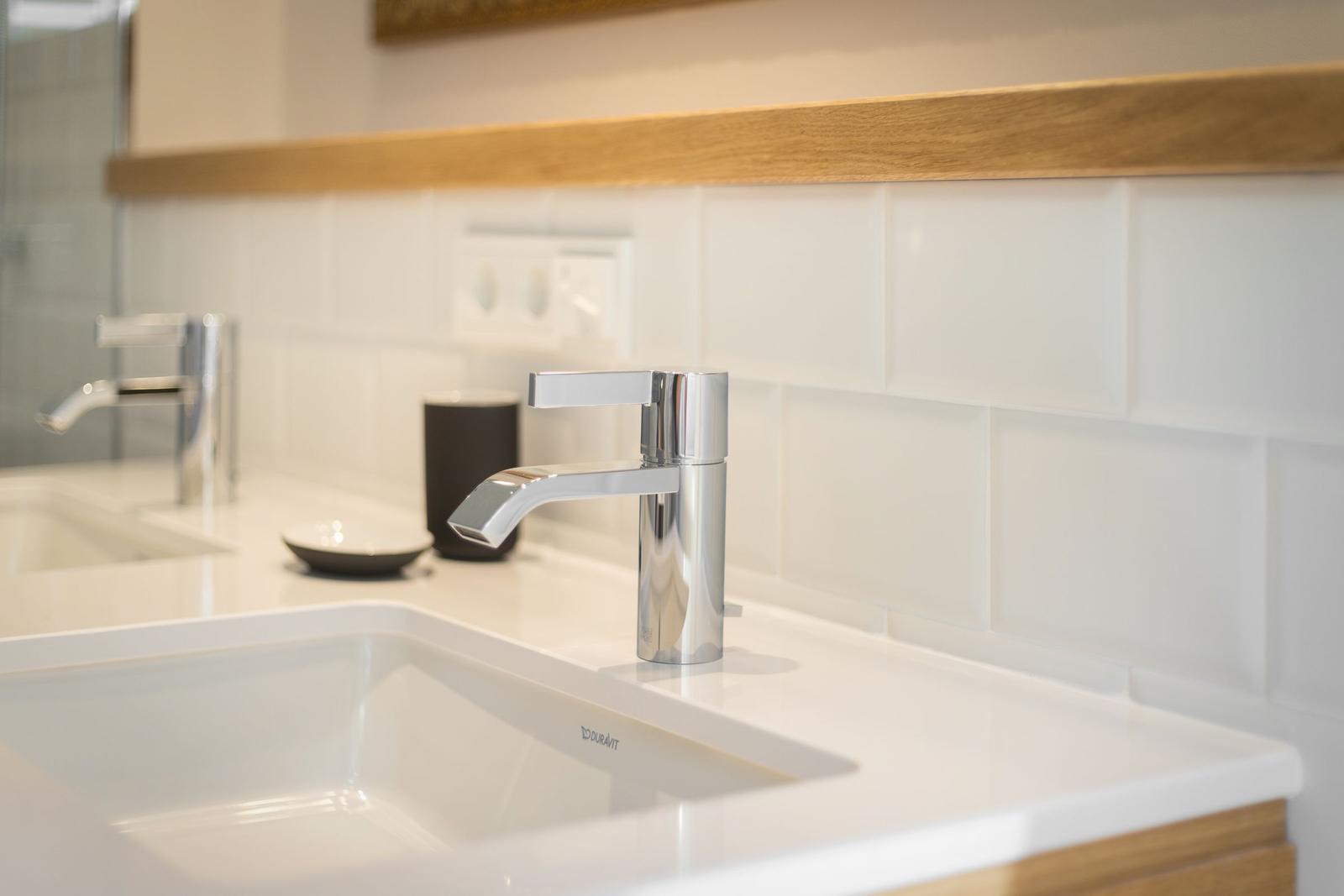 Waschbecken mit Chromarmatur und Holzoberkante