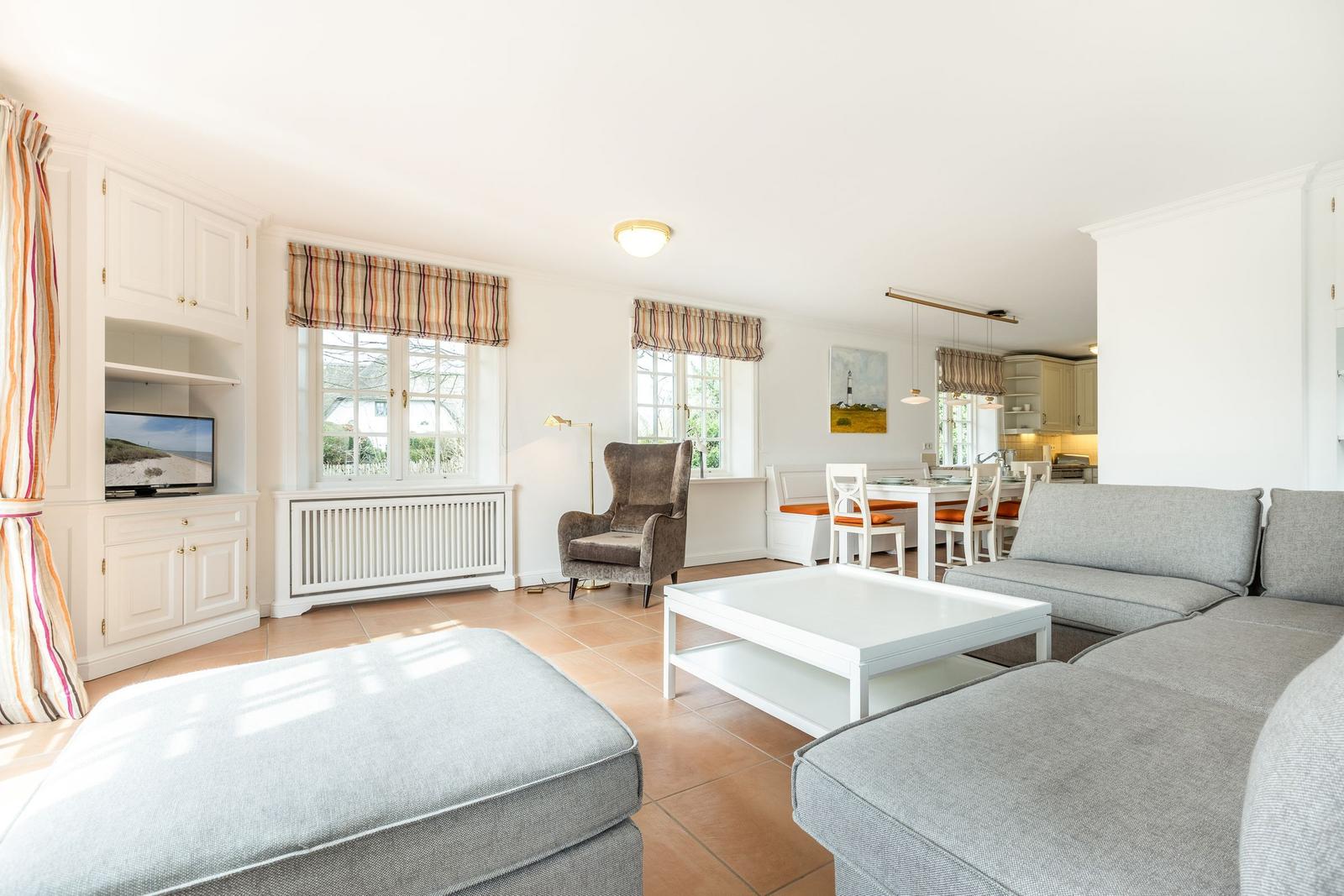 Wohn- und Essbereich mit Sofa, Couchtisch und TV-Ecke.
