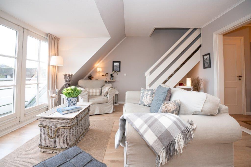Wohnzimmer mit Sofa, Sessel und Kamin im Dachgeschoss