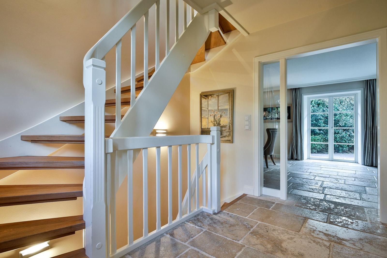 Haus mit Treppe, Steinboden und Blick auf Garten