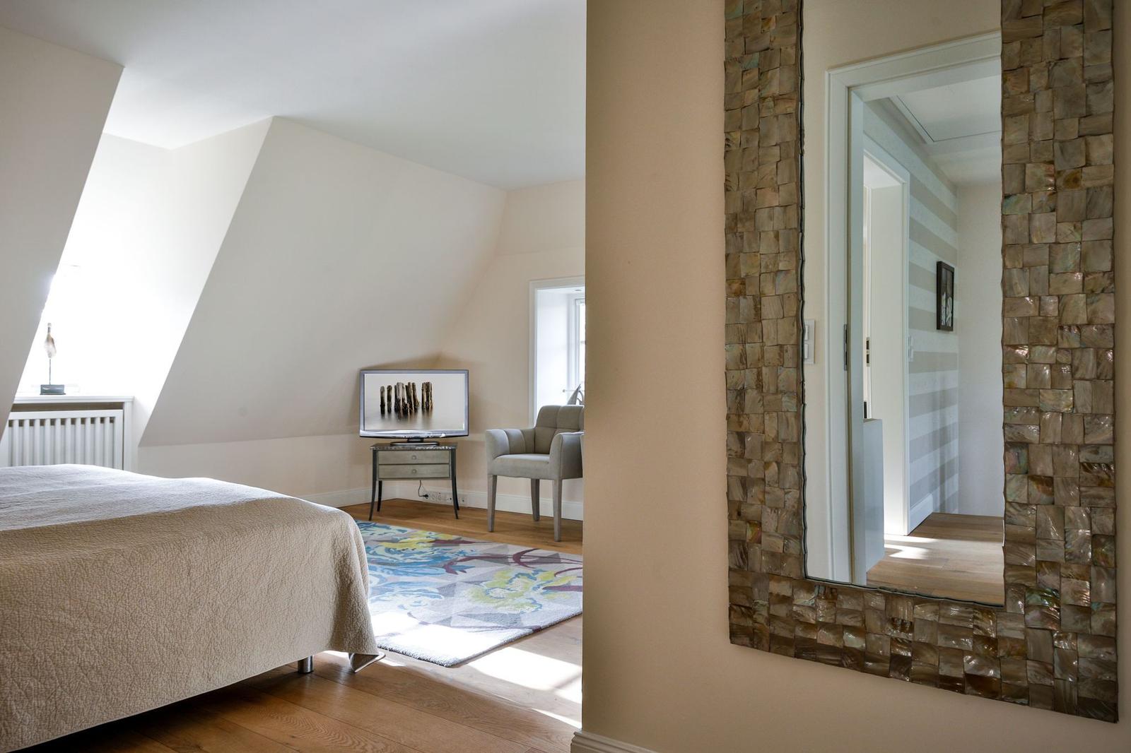 Schlafzimmer mit Dachschrägen, Spiegel und Bett