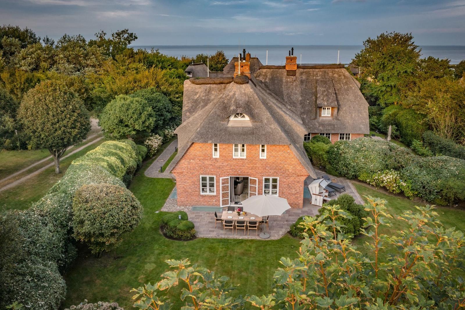 Dorfhaus mit Strohdach, Garten und Meerblick.
