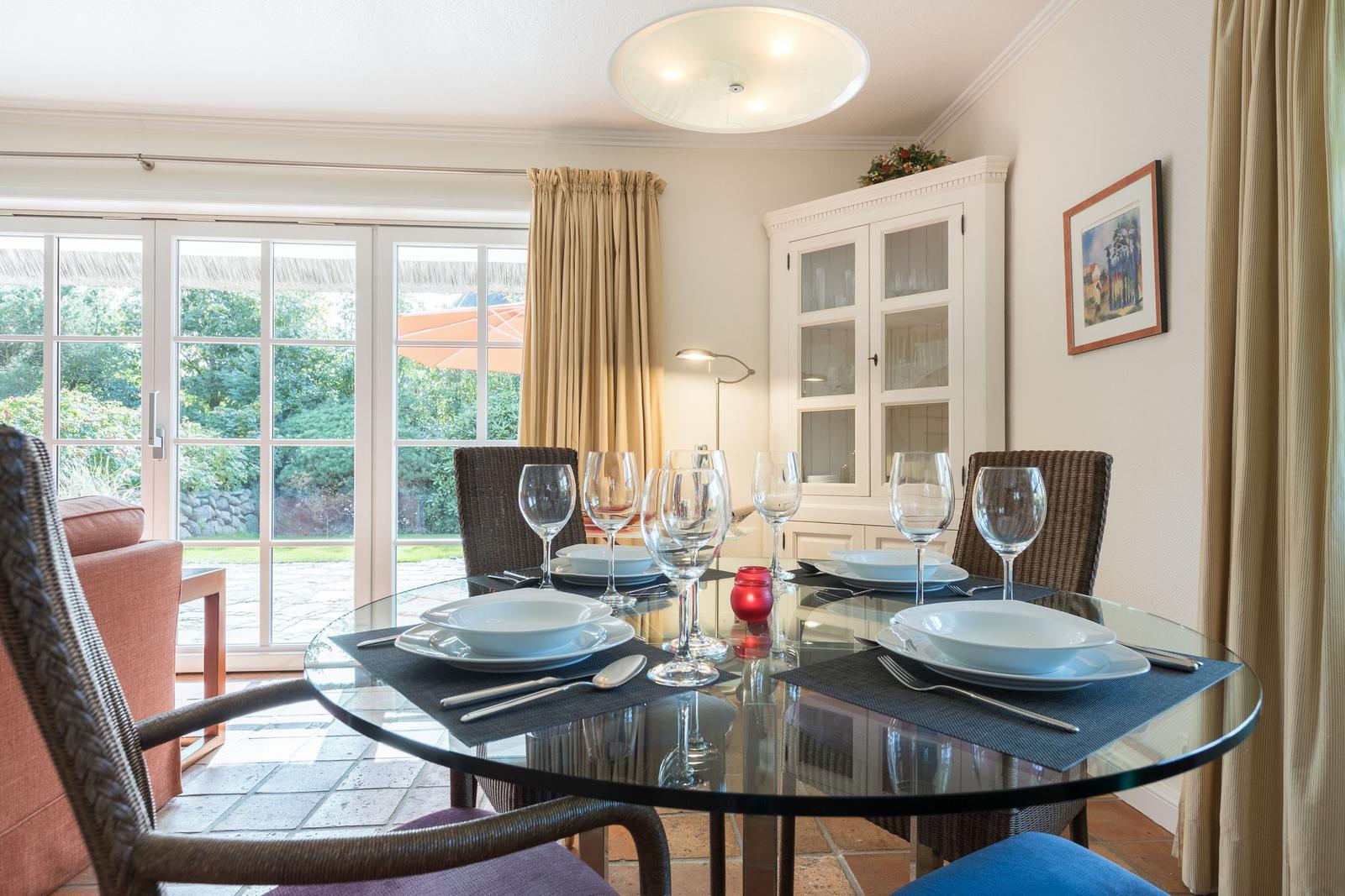 Glasrundtisch mit Platz für sechs Personen und Blick auf den Garten.