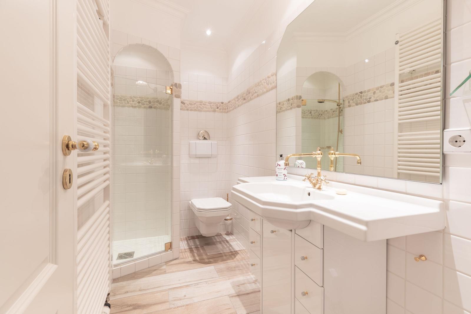 Bathroom with shower, toilet, and sink with mirror.