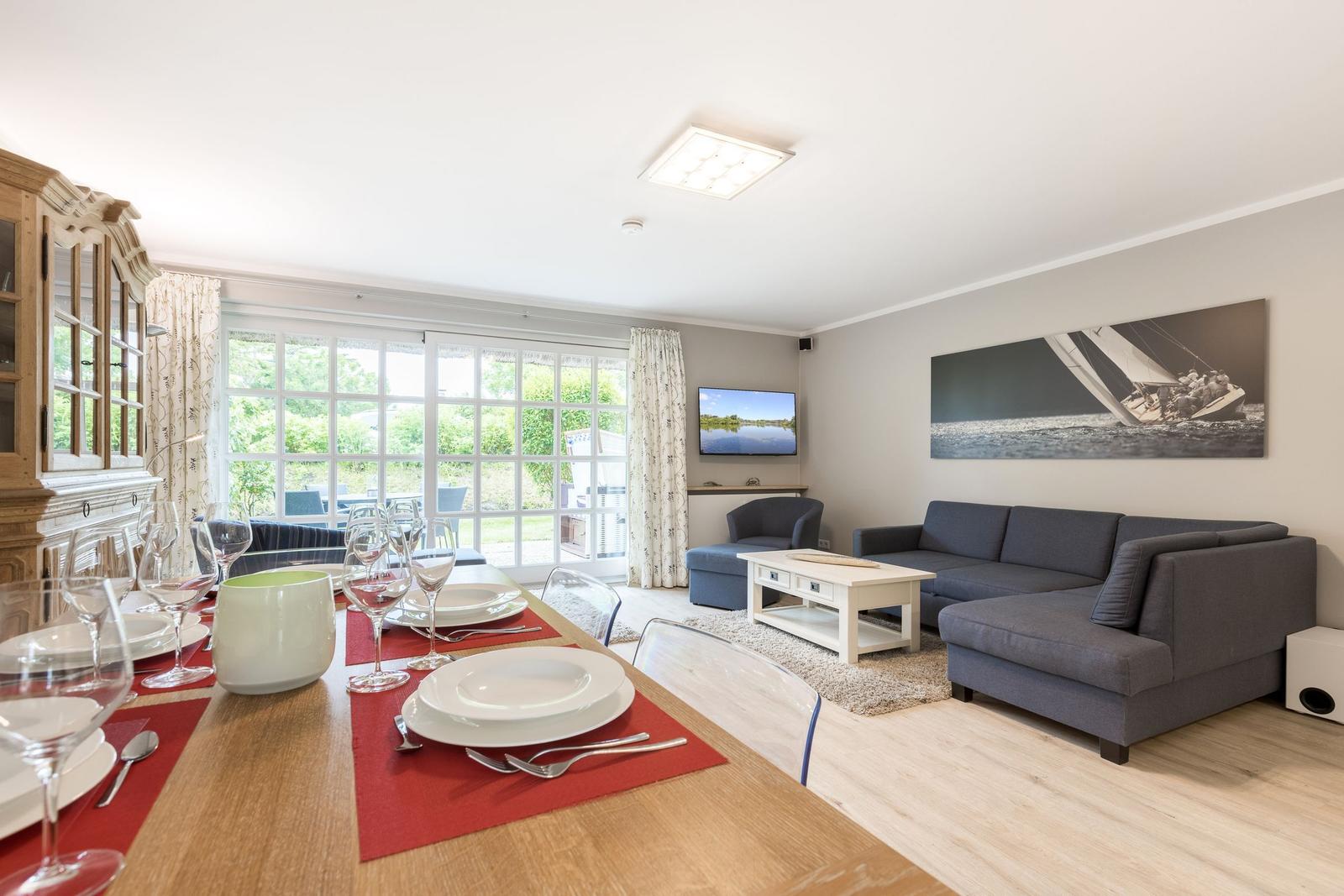 Essbereich mit Tisch und Stühlen, Wohnzimmer mit Sofa und Fernseher.