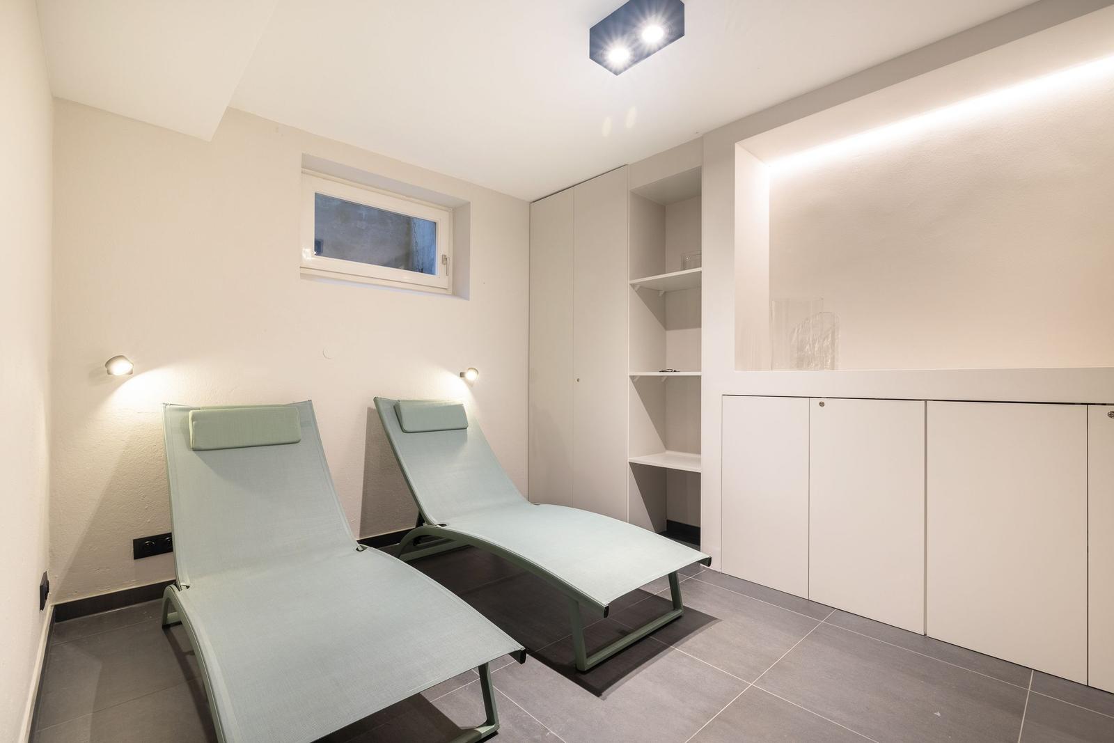 Zwei Liegestühle in einem Raum mit Schränken und Fenster