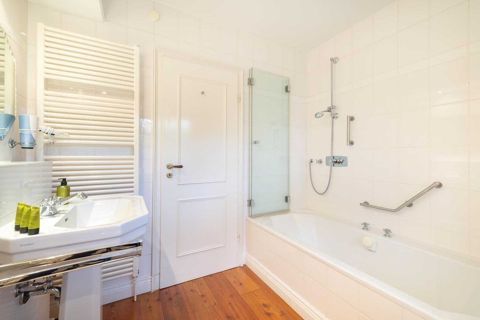 Badezimmer mit Badewanne, Dusche und Waschbecken.