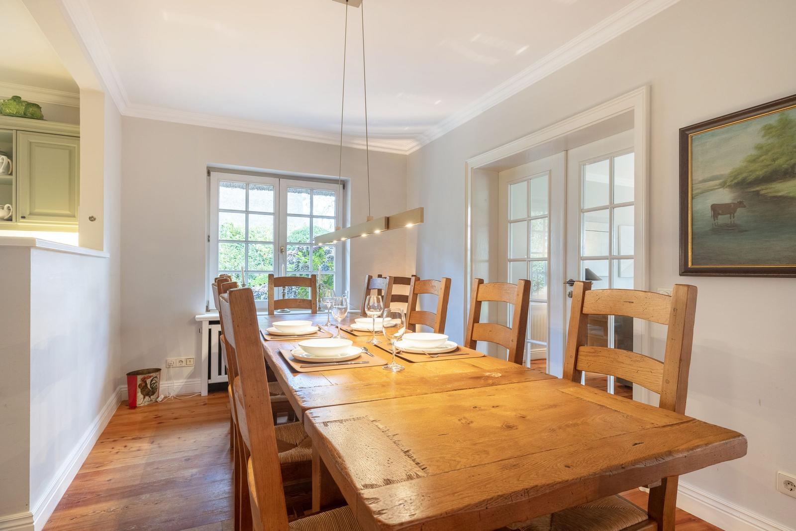 Esszimmer mit Holztisch, Stühlen und Fenster zur Außenseite.