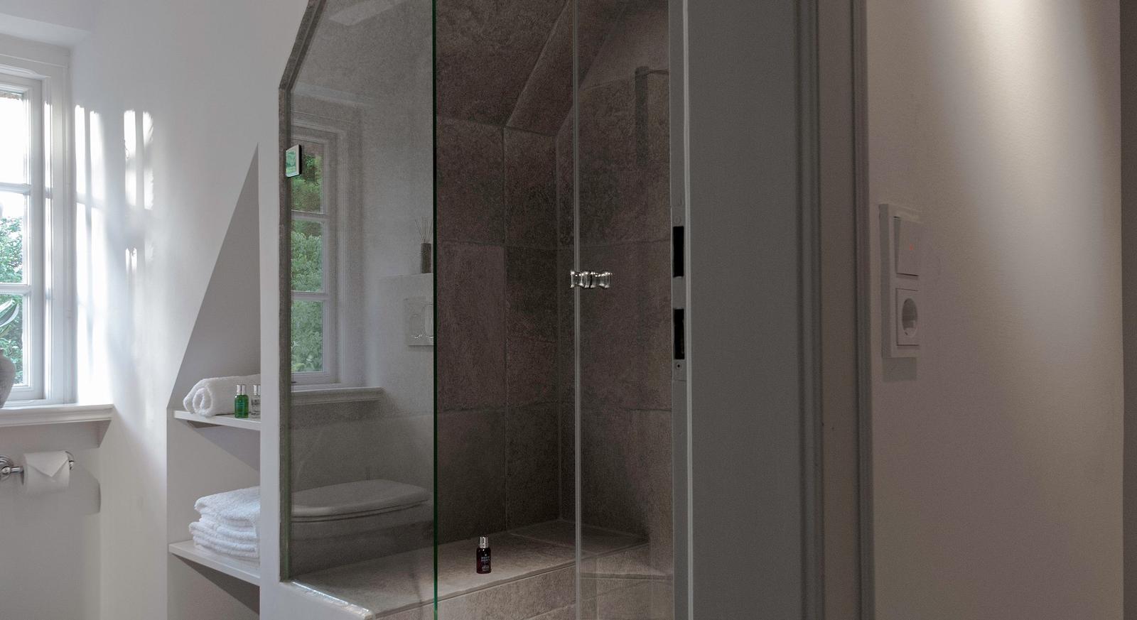 Bath with shower, window, and shelf with towels