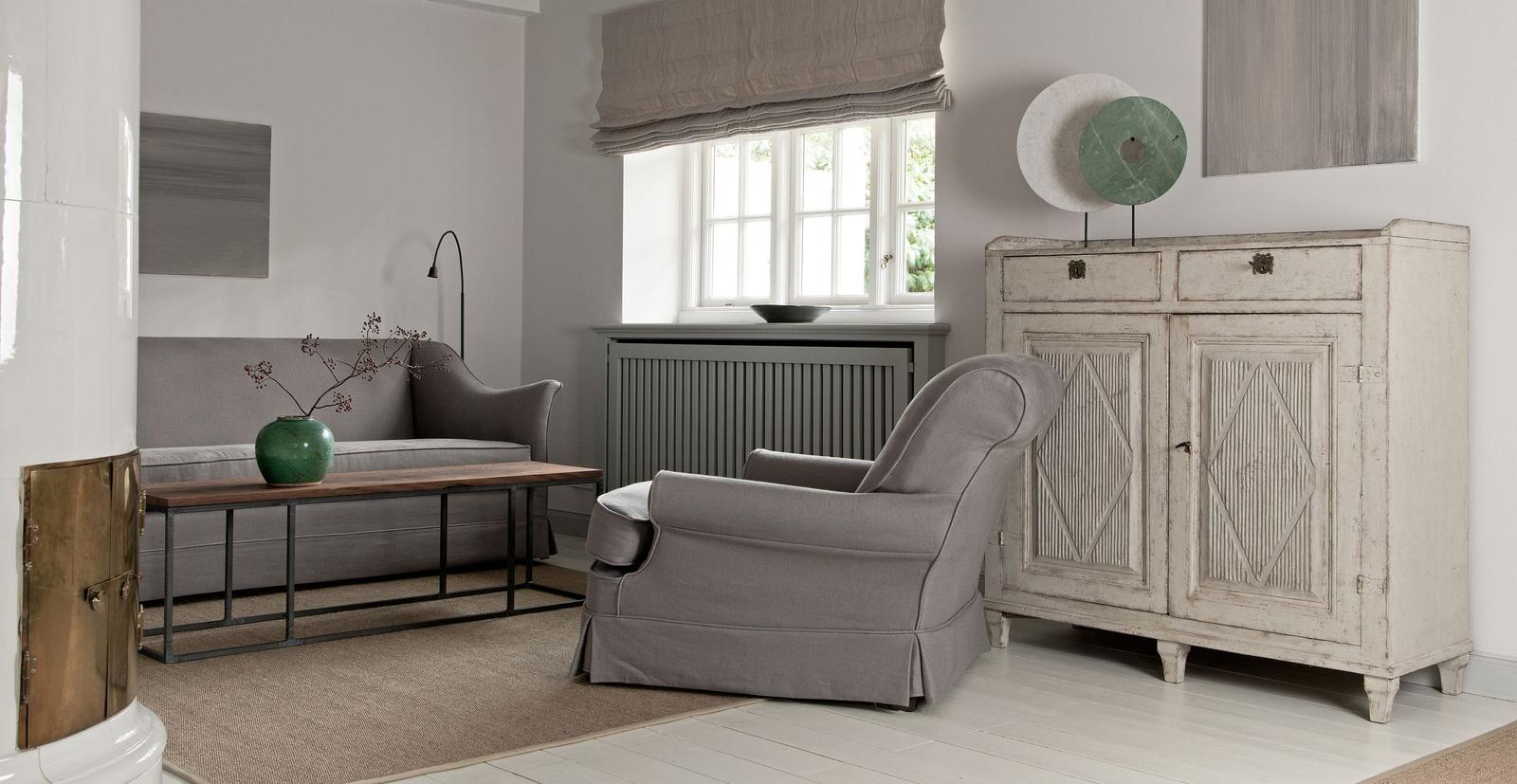 A living room with a gray sofa, armchair, and a white cabinet.