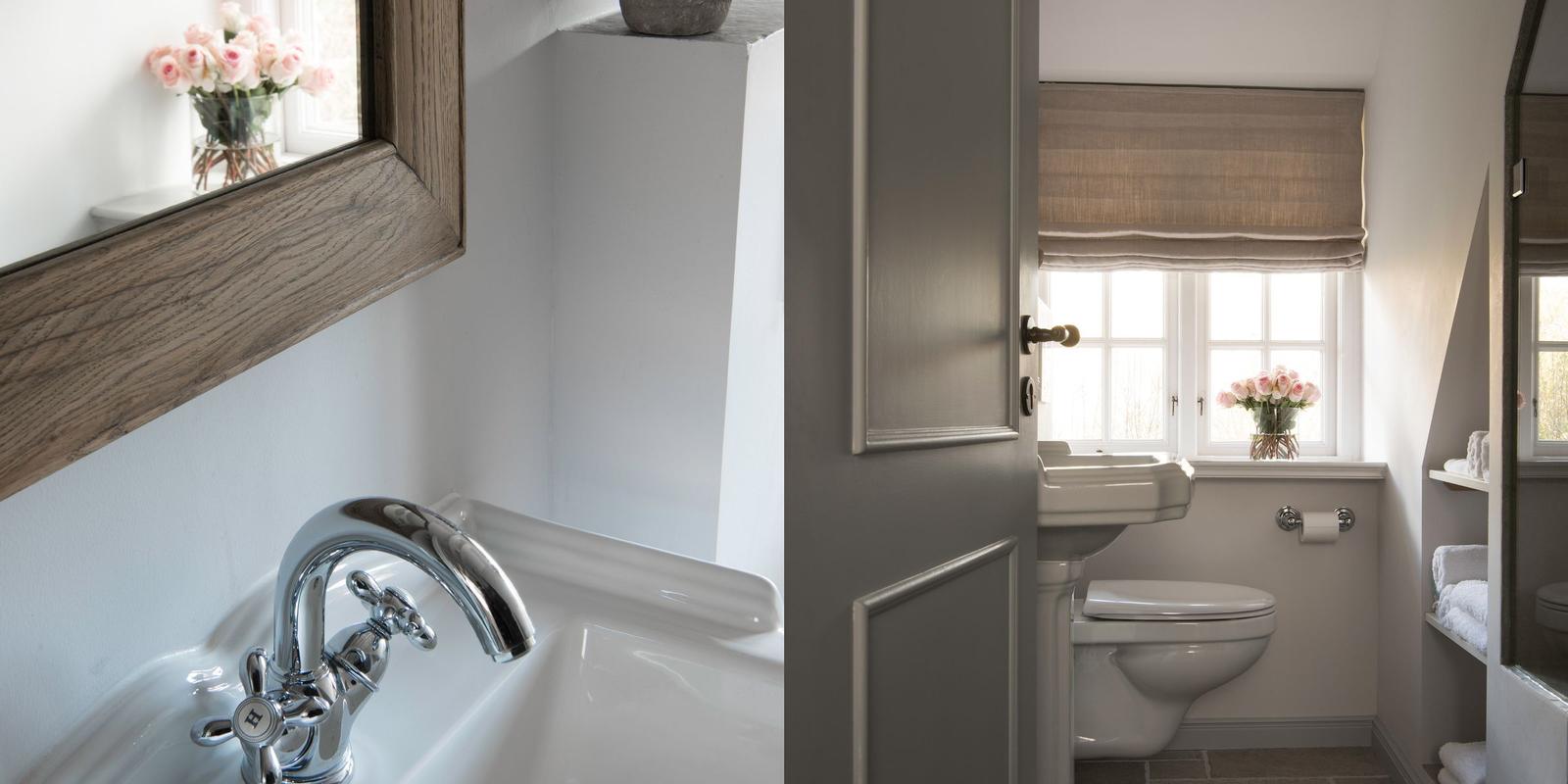 Bathroom with sink, toilet, and window with flowers.