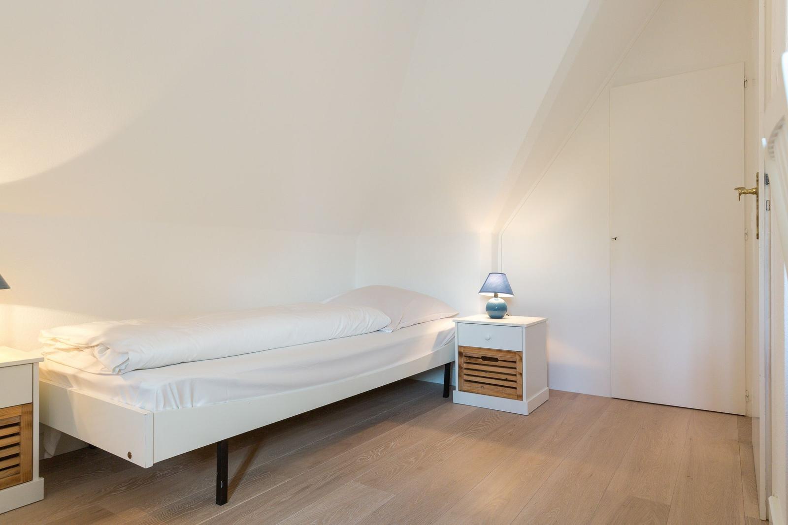 Schlafzimmer mit Doppelbett, zwei Nachttischen und Holzboden.
