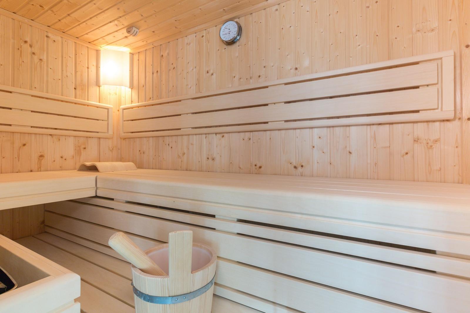 Sauna mit Holzbank und Wasserbucket