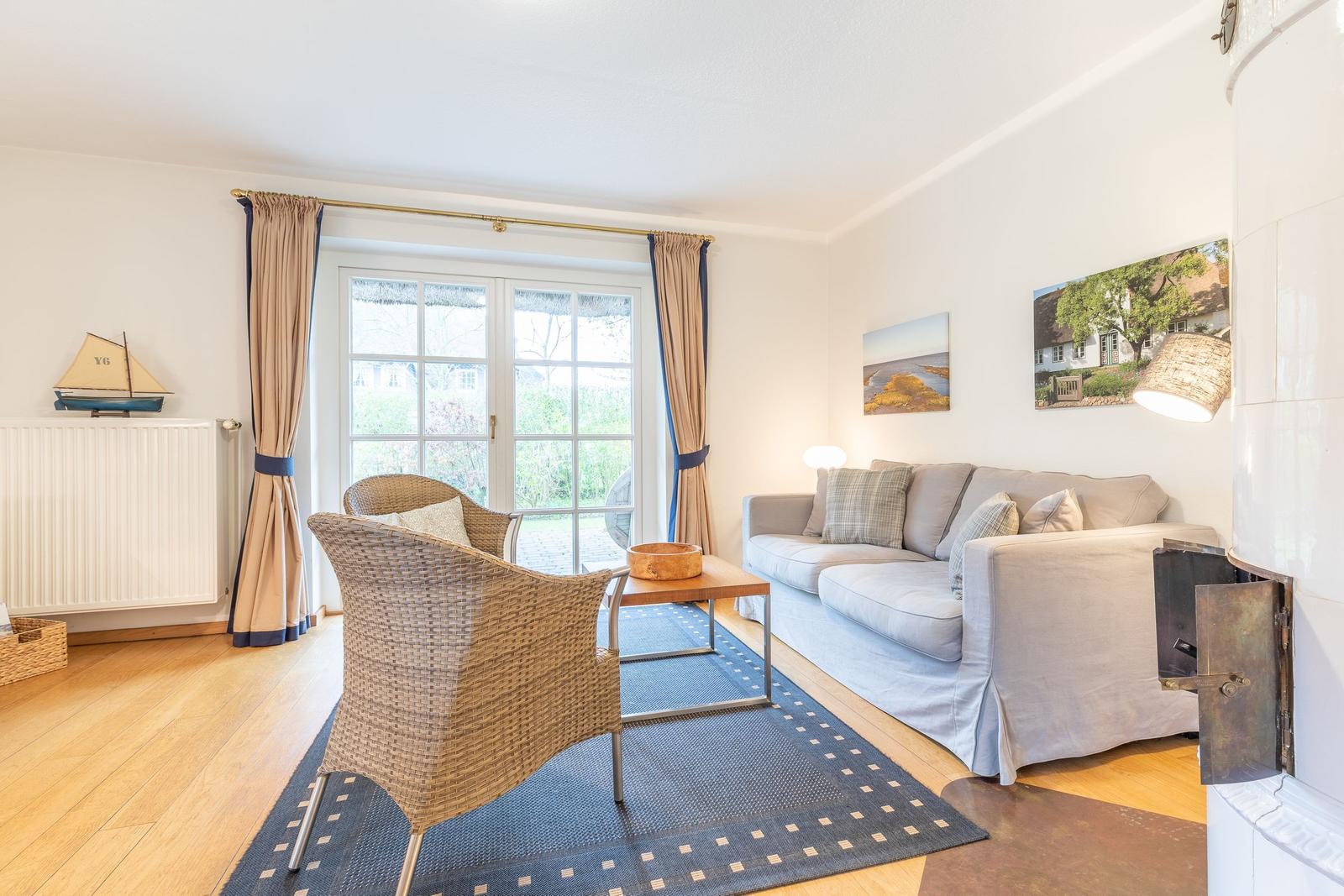 Wohnzimmer mit Sofa, Stuhl und Fenster zur Auöenansicht.