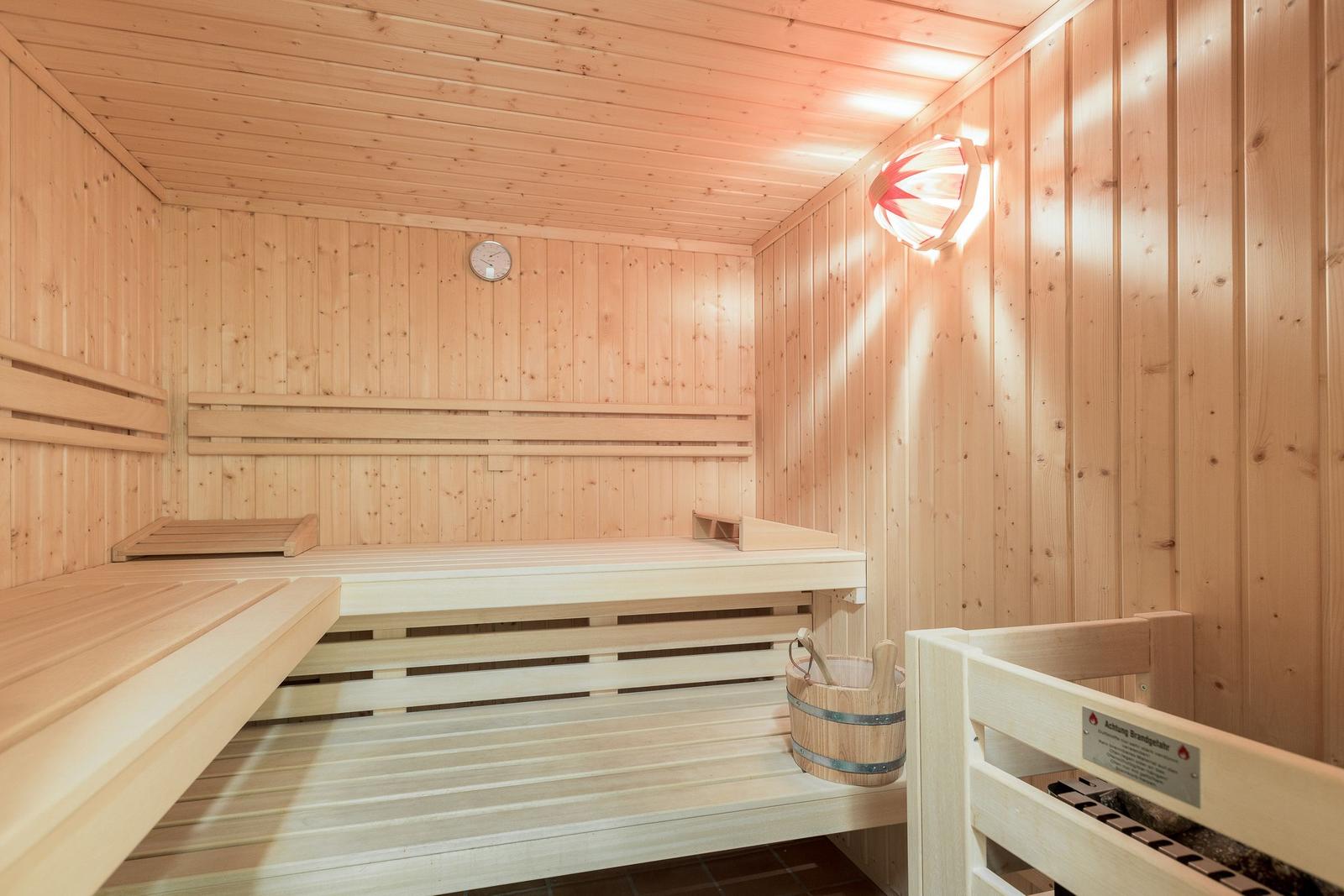 Sauna mit Holzbank, Thermometer und Holzeimer