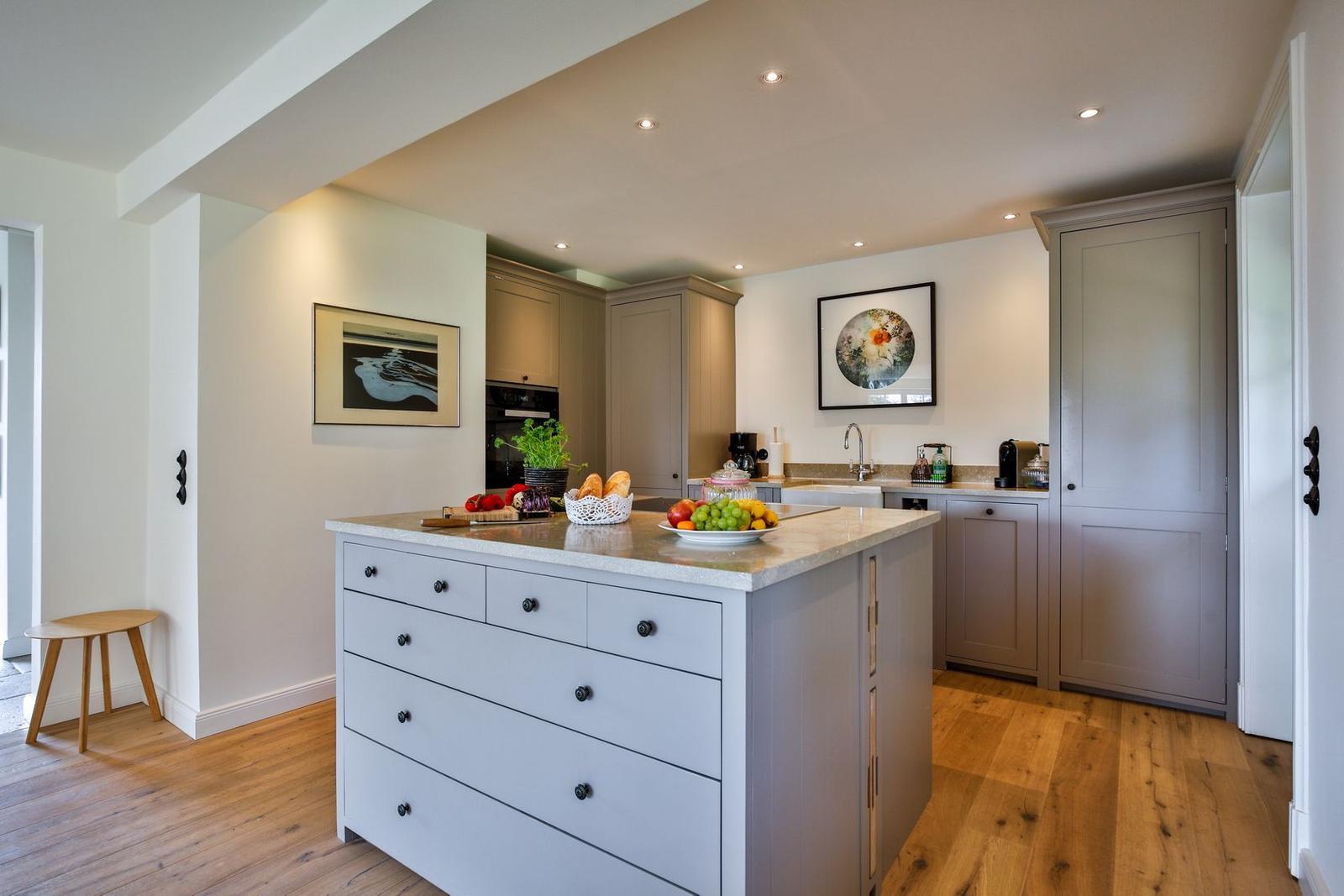 Kitchen with island, wooden floor, and light walls.
