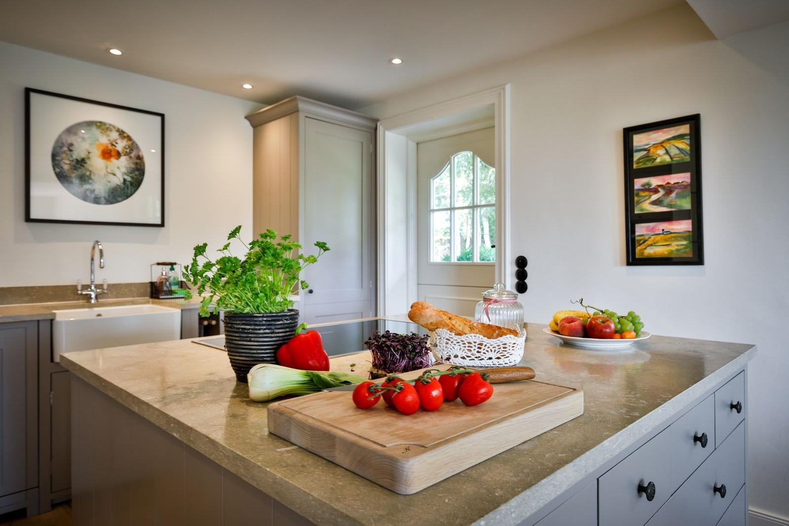 Kitchen with countertop, fruit, vegetables, and kitchen cabinets.