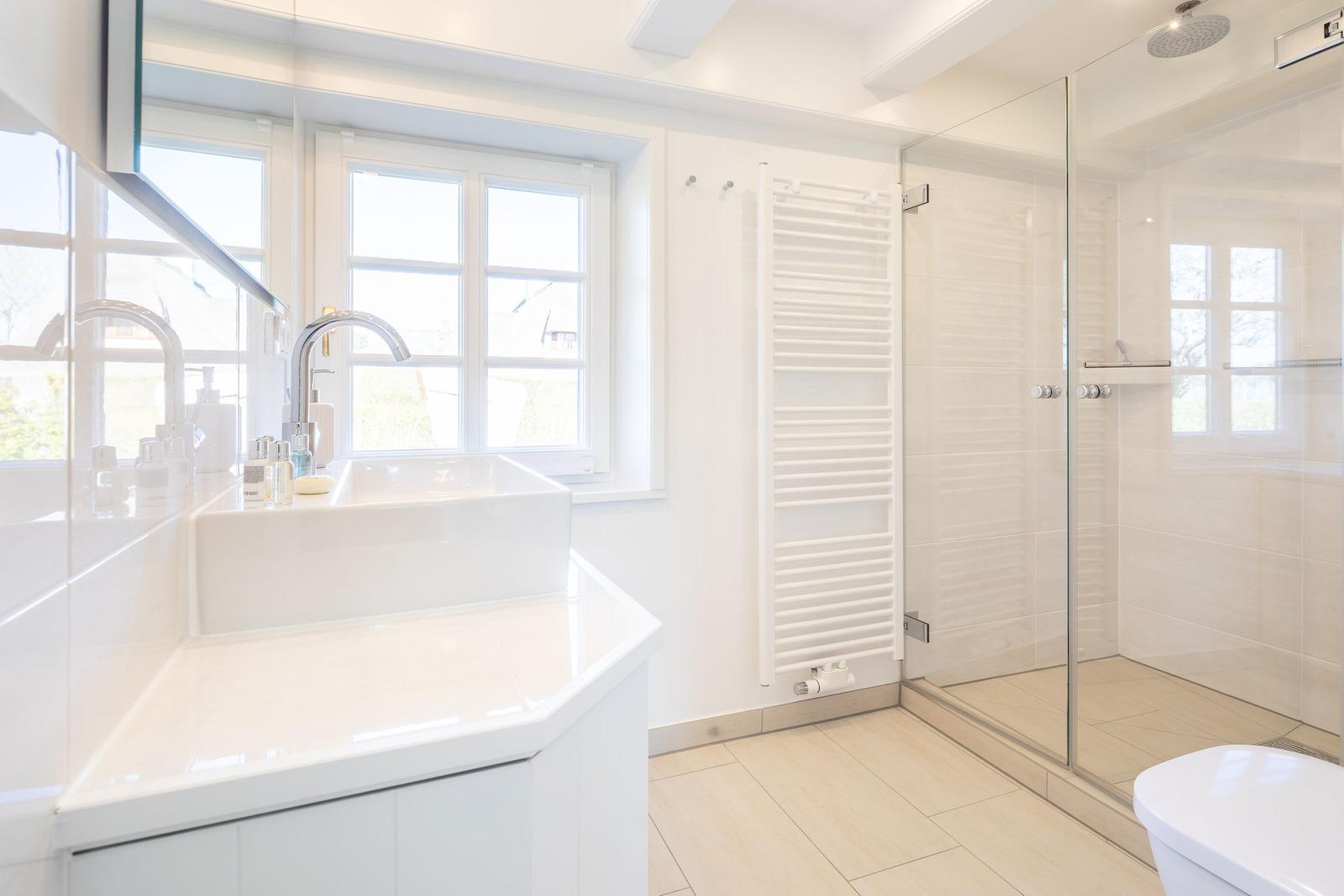 Badezimmer mit Dusche, Waschbecken und Fenster