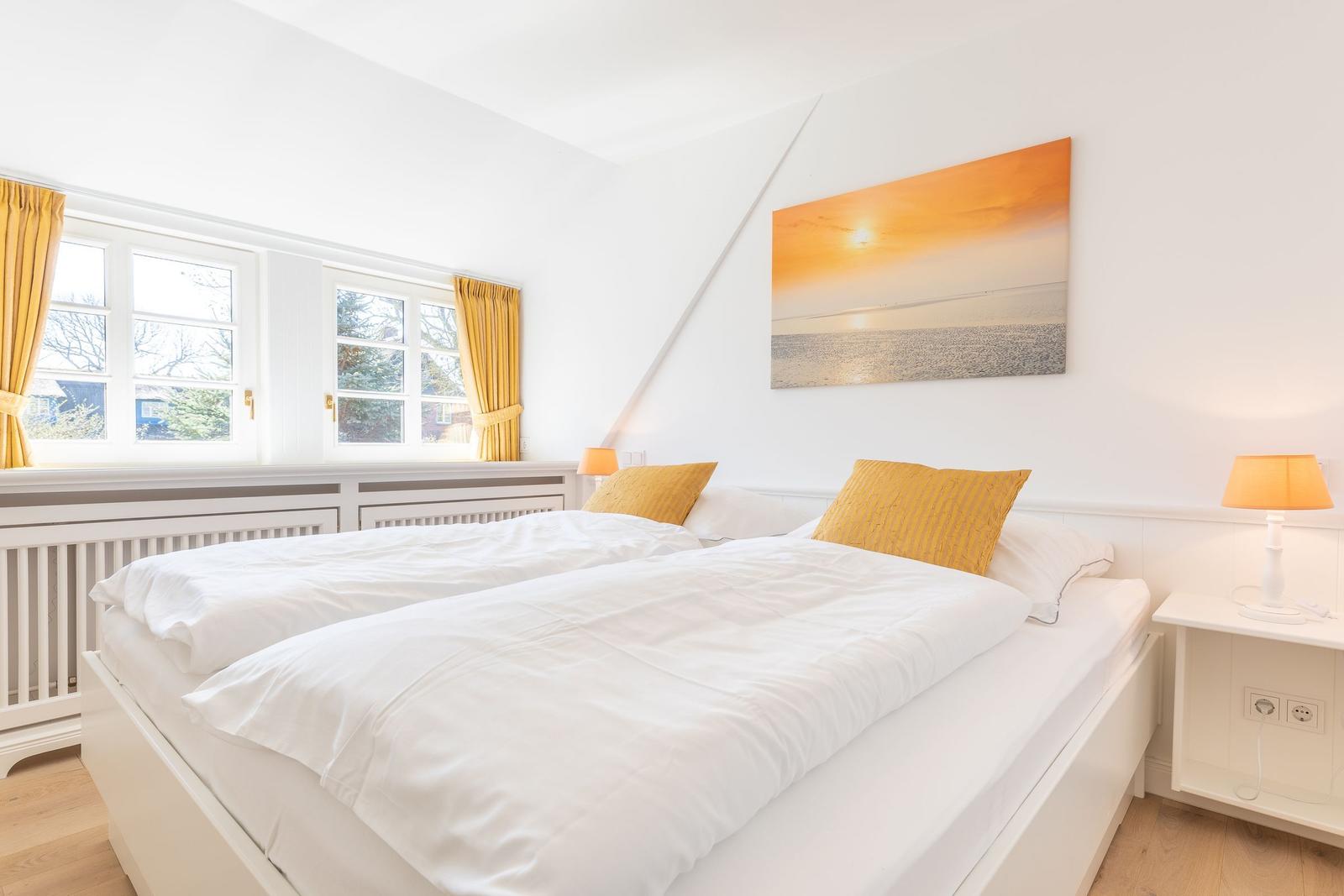 Schlafzimmer mit Doppelbett, Fenstern und Wandbild