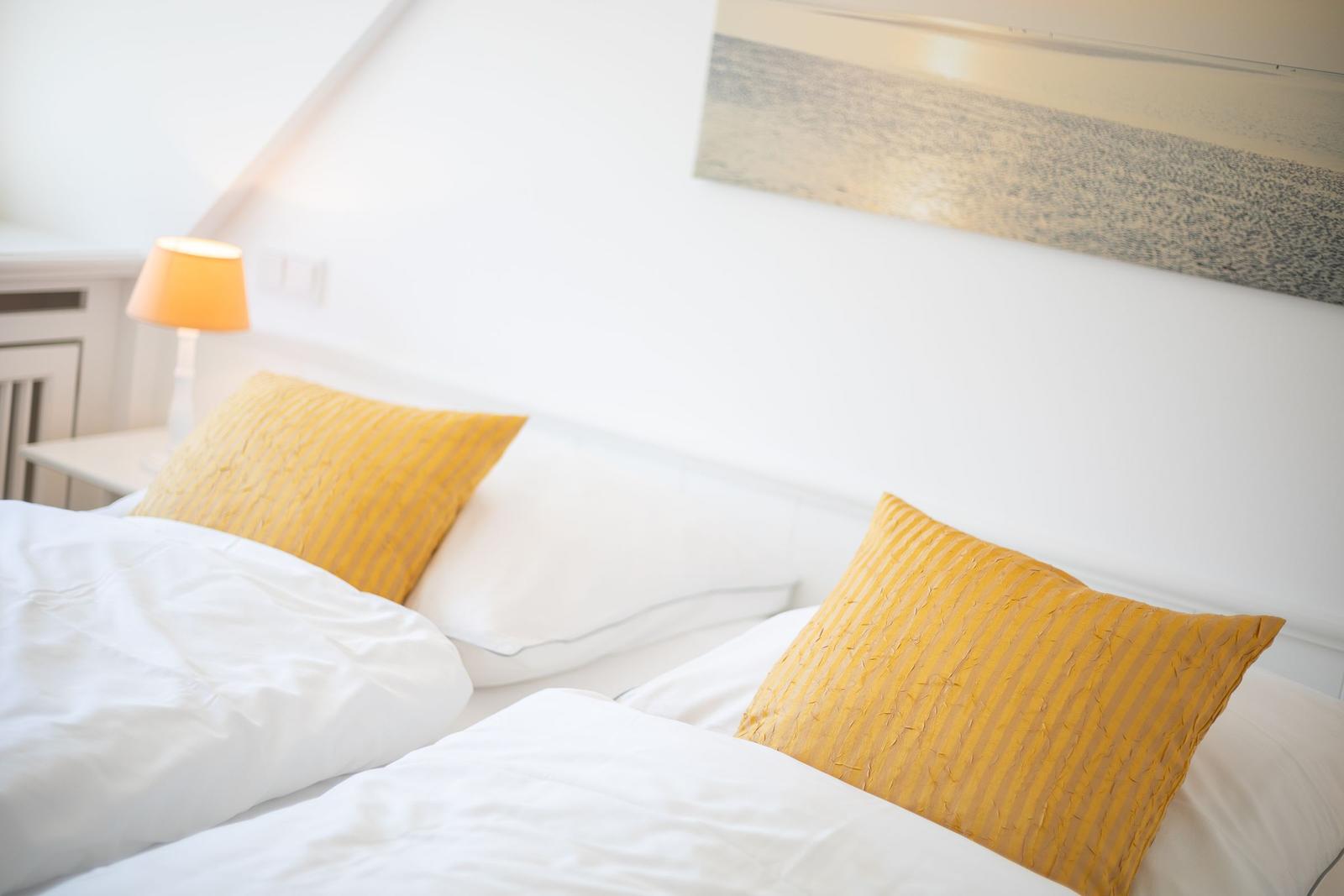 Schlafzimmer mit Bett, Kissen und Lampe