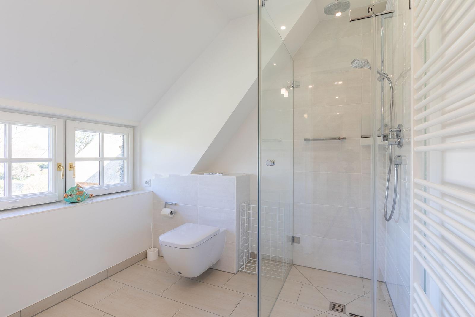Badezimmer mit Dusche, Toilette und Fenster
