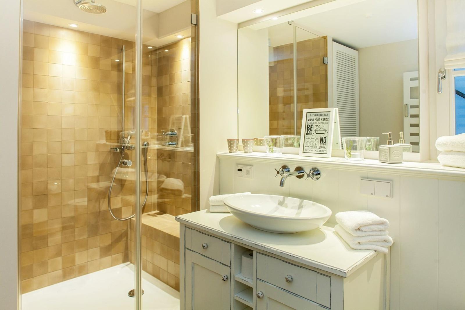 Bathroom with shower, sink, and mirror