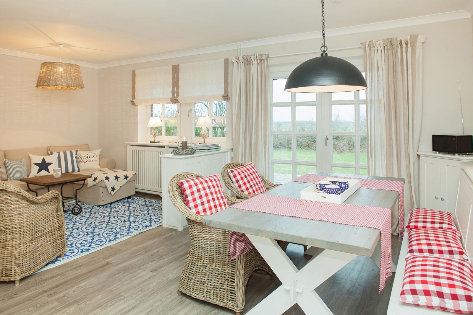 Dining area with table and chairs, seating with cushions and window for view.