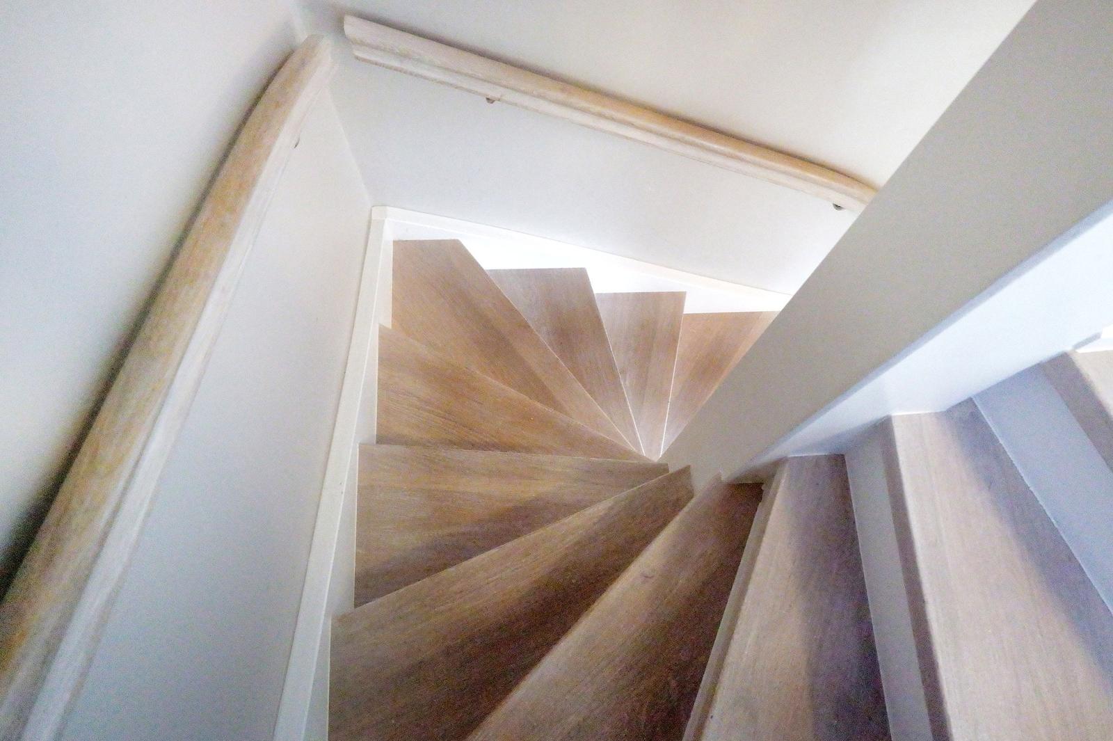 Holztreppe mit Geländer führt nach oben.