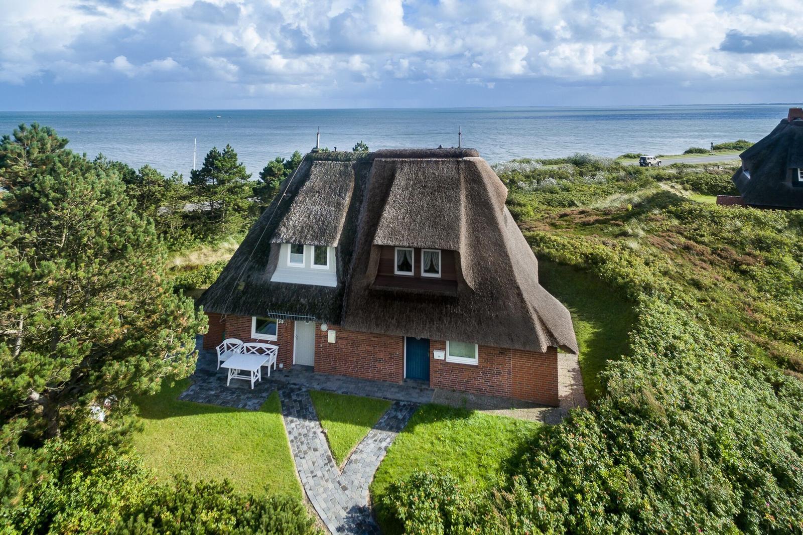 Dorfhaus mit Strohdach, Garten und Meerblick.