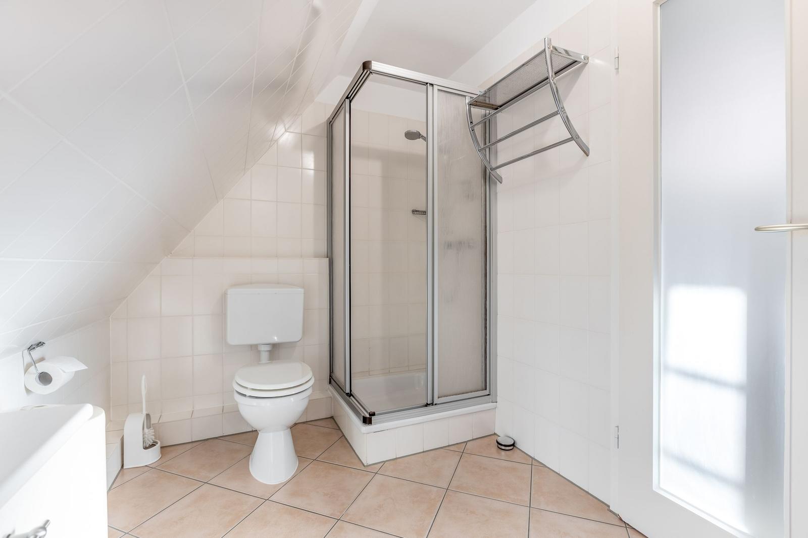 Badezimmer mit Dusche, Toilette und Waschbecken.