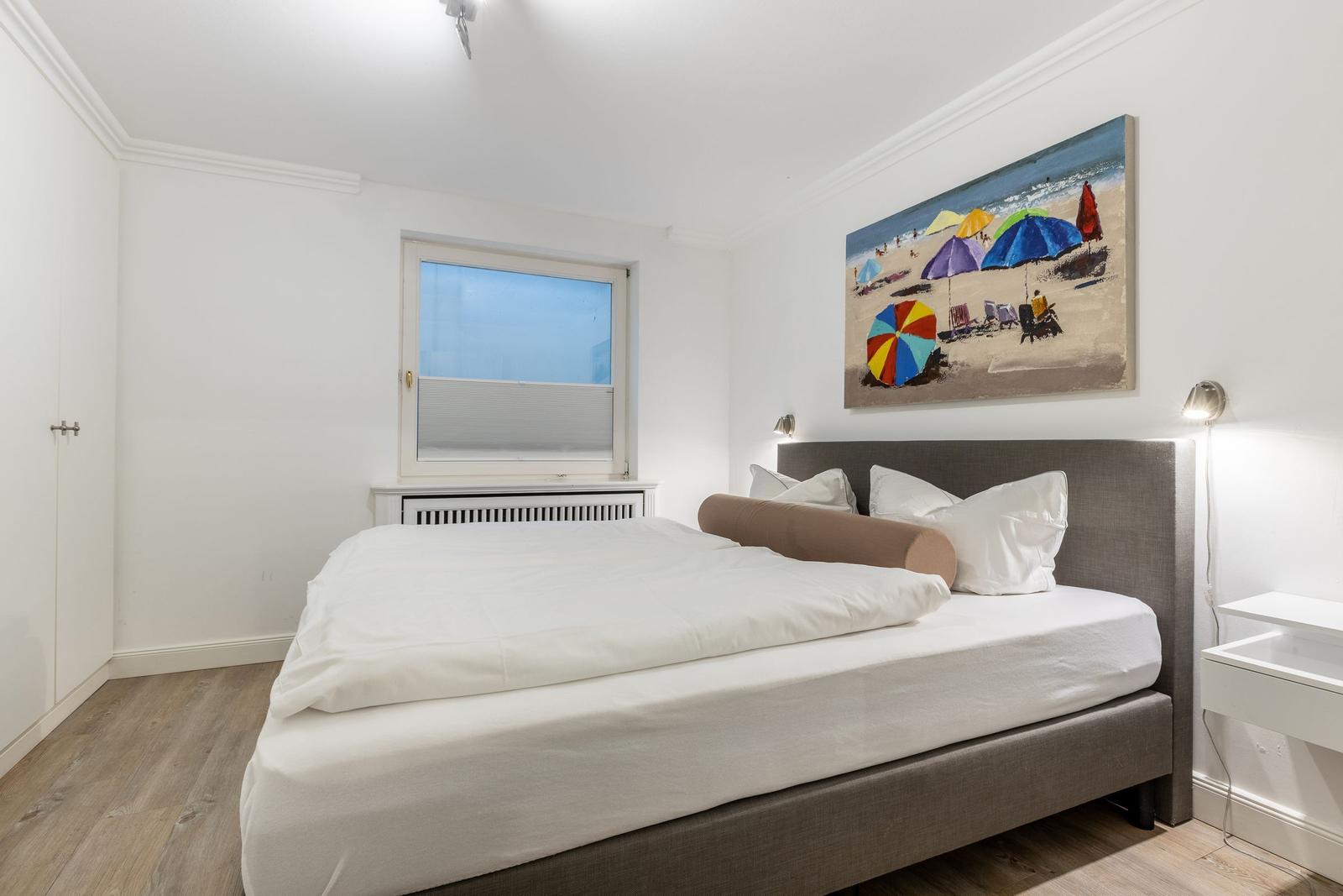 Schlafzimmer mit Bett, Wandbild und Fenster