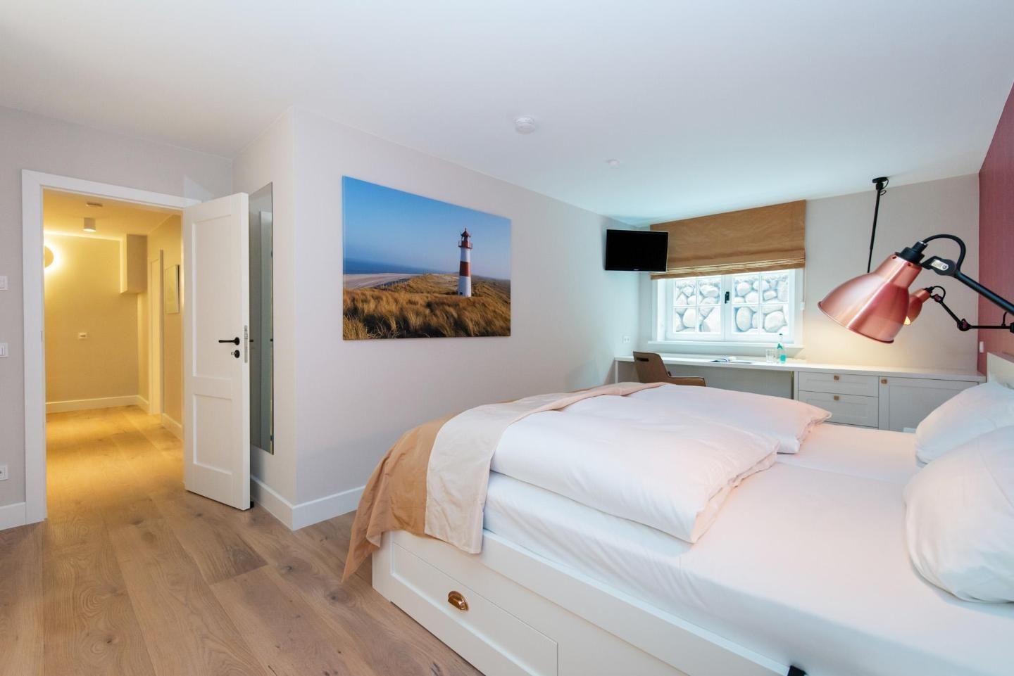 Bedroom with bed, wall art, and desk