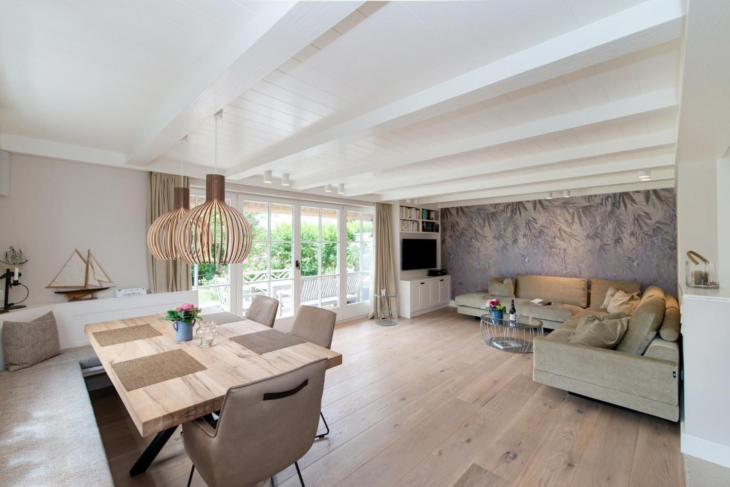 Large living and dining area with wooden floor and dining space.