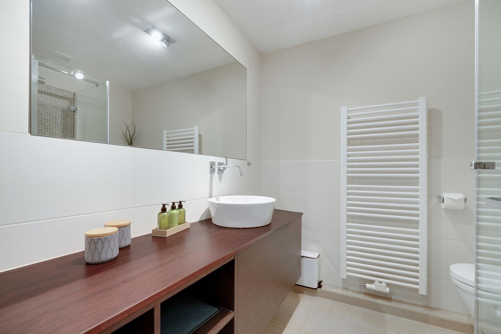 Badezimmer mit Waschbecken, Spiegel und Heizkörper