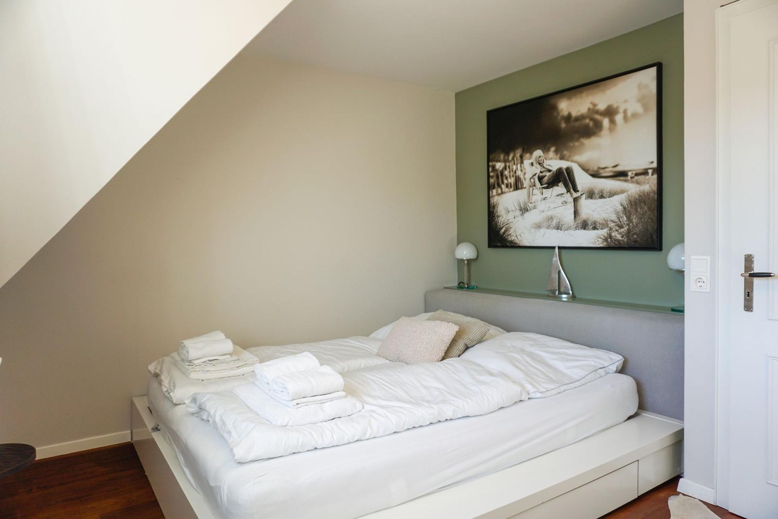 Schlafzimmer mit Bett, Wandbild und Lampe