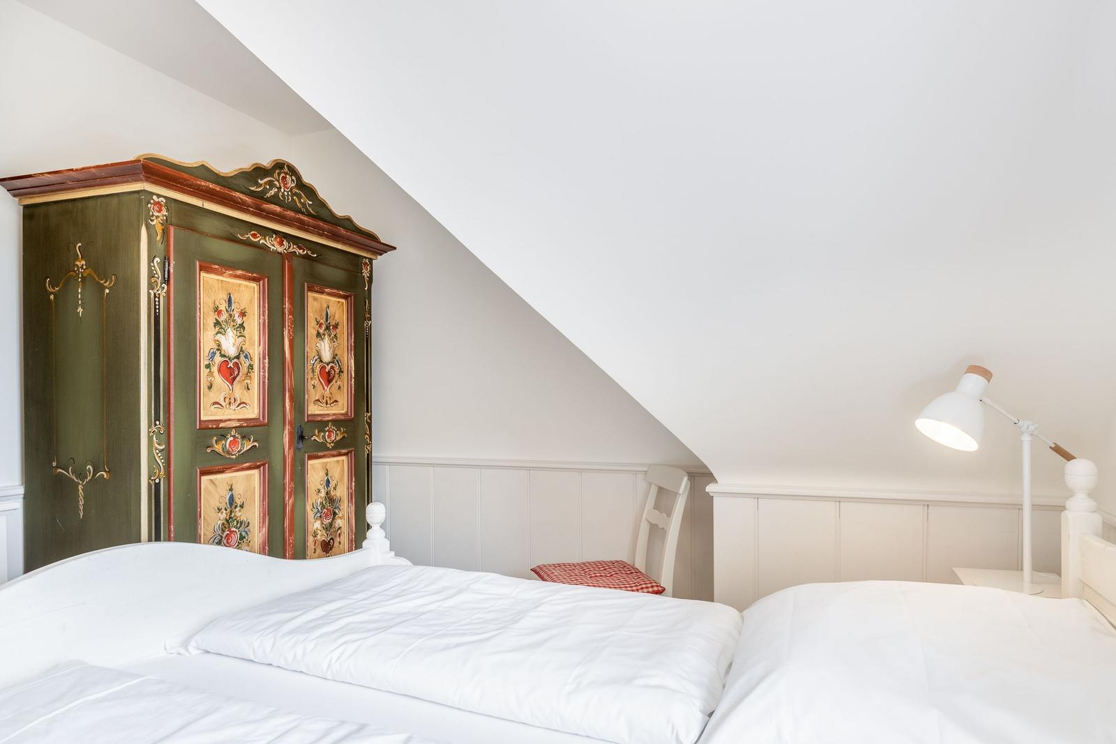 Schlafzimmer mit Bett, Kleiderschrank und Nachttisch.