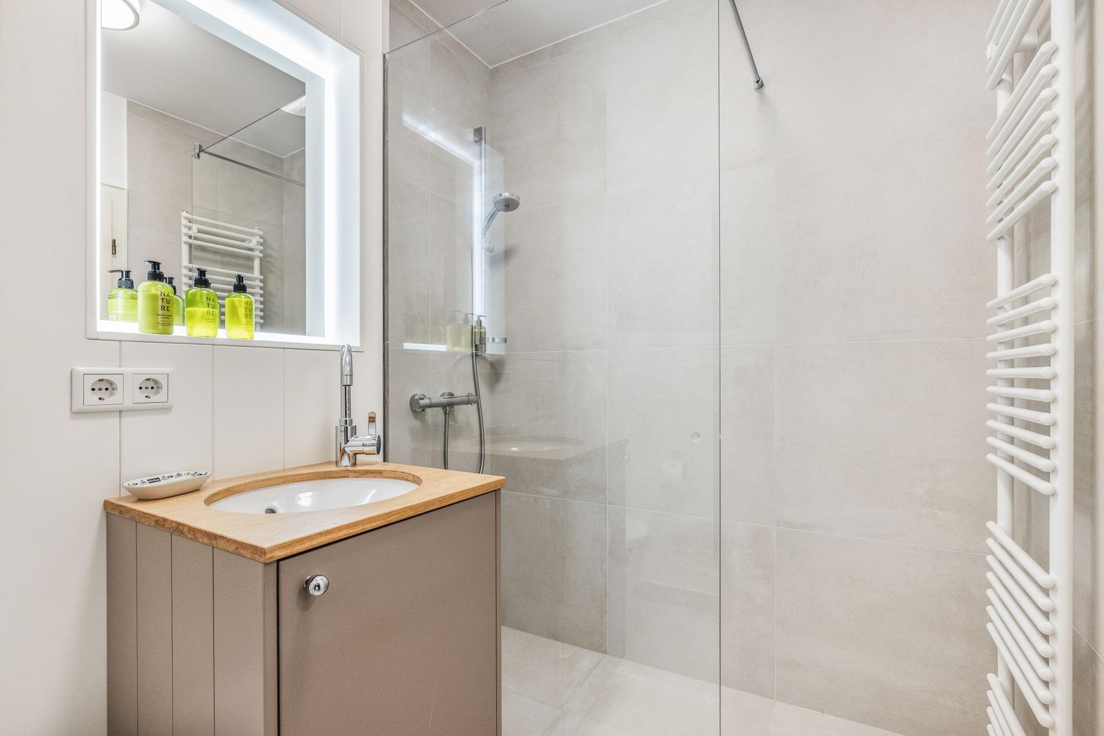 Bad mit Dusche, Waschbecken und Heizkörper