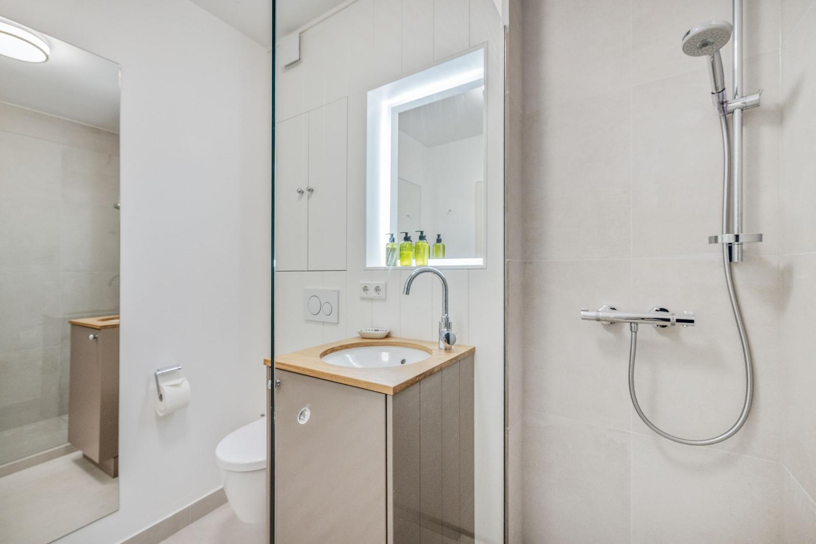 Badezimmer mit Dusche, Waschbecken und Toilette