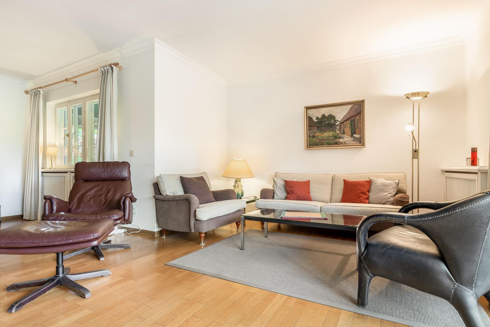 Living room with sofa, armchairs, and wooden floor