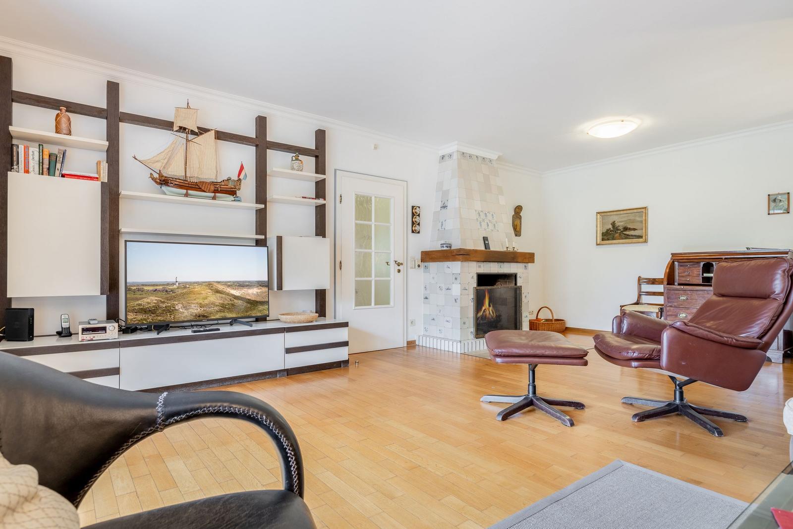 Living room with fireplace, TV, and brown leather armchair.