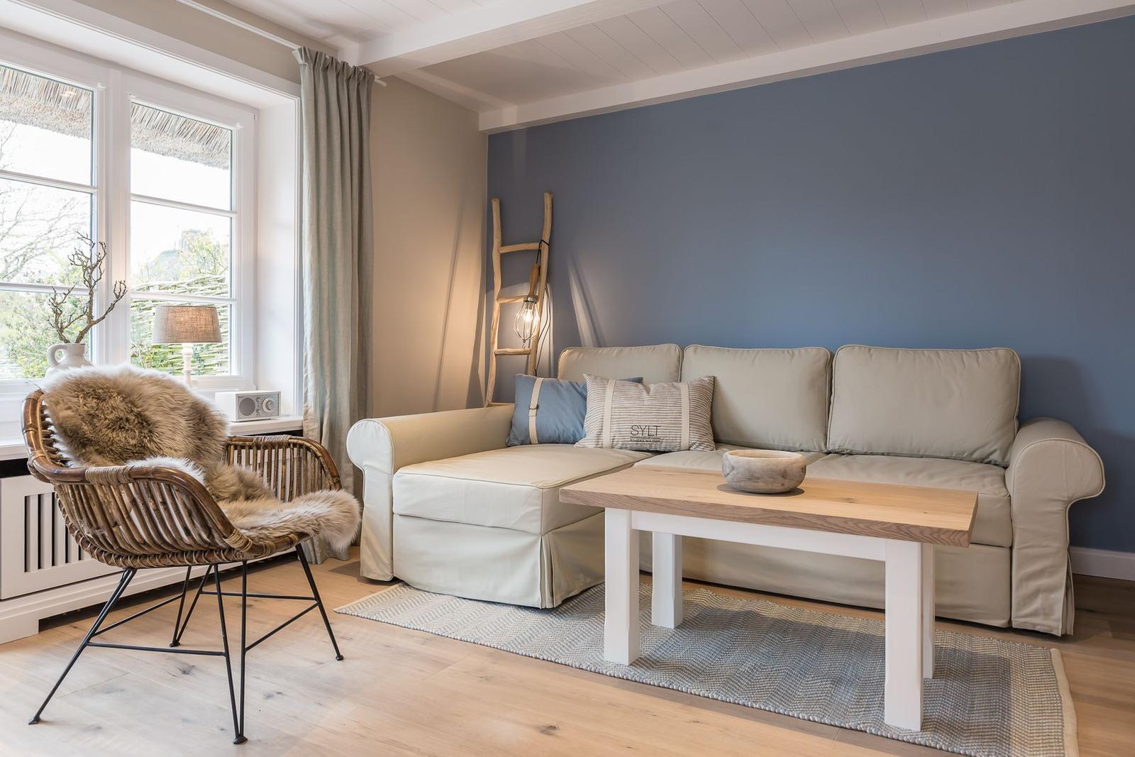 Living room with sofa, coffee table, and chair by large window.