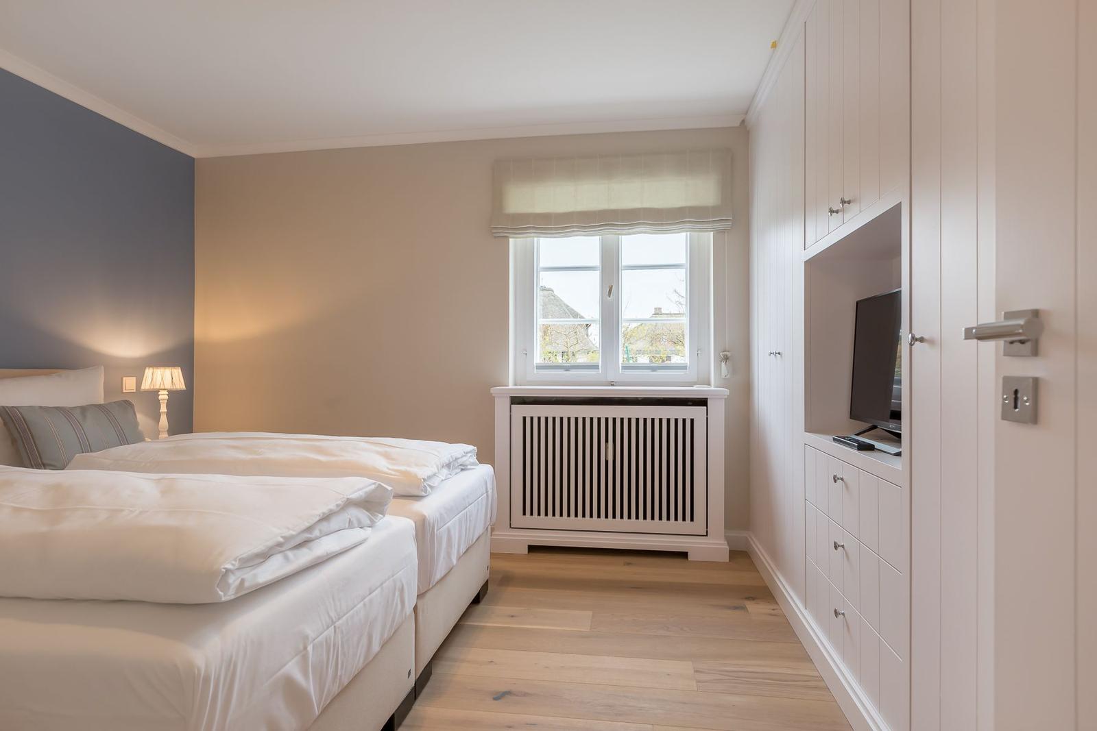 Bedroom with double bed, window, and built-in TV area.