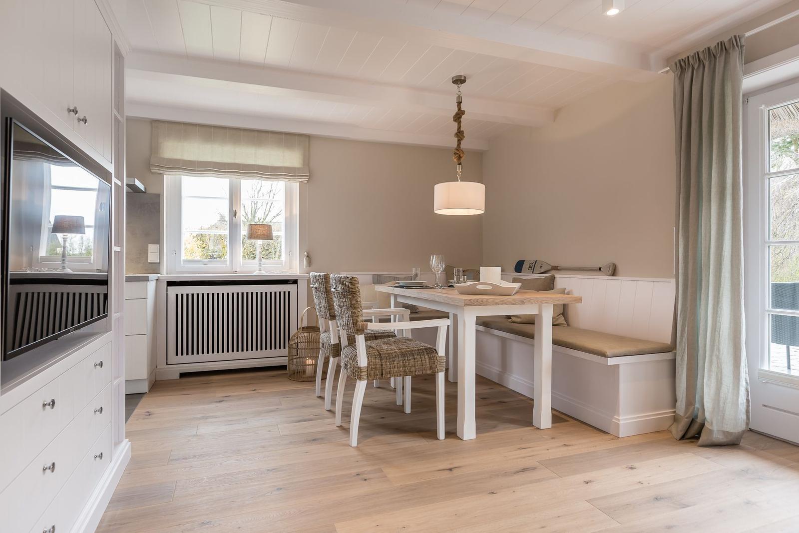 Dining area with table, chairs, and bench along the wall.