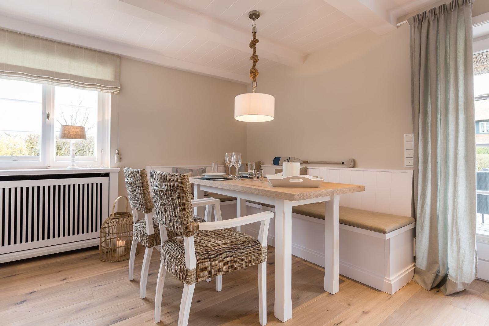 Dining room with wooden table, bench, and wicker chairs.