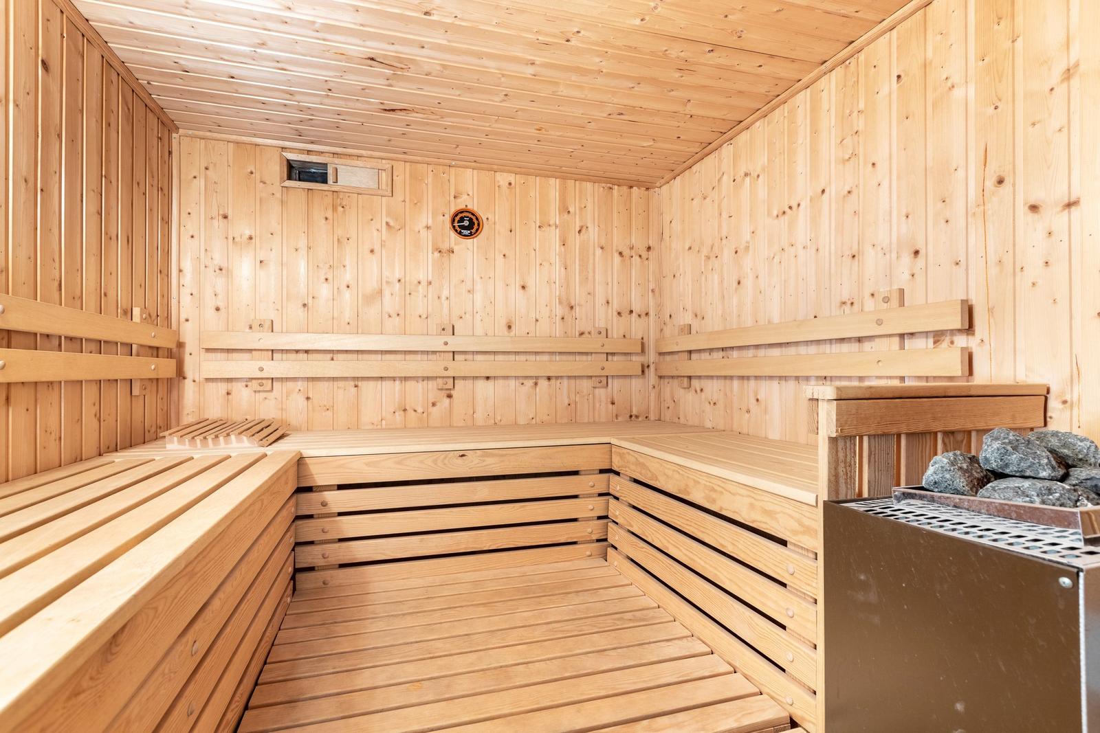 Holzsauna mit Sitzbänken und Steinkessel
