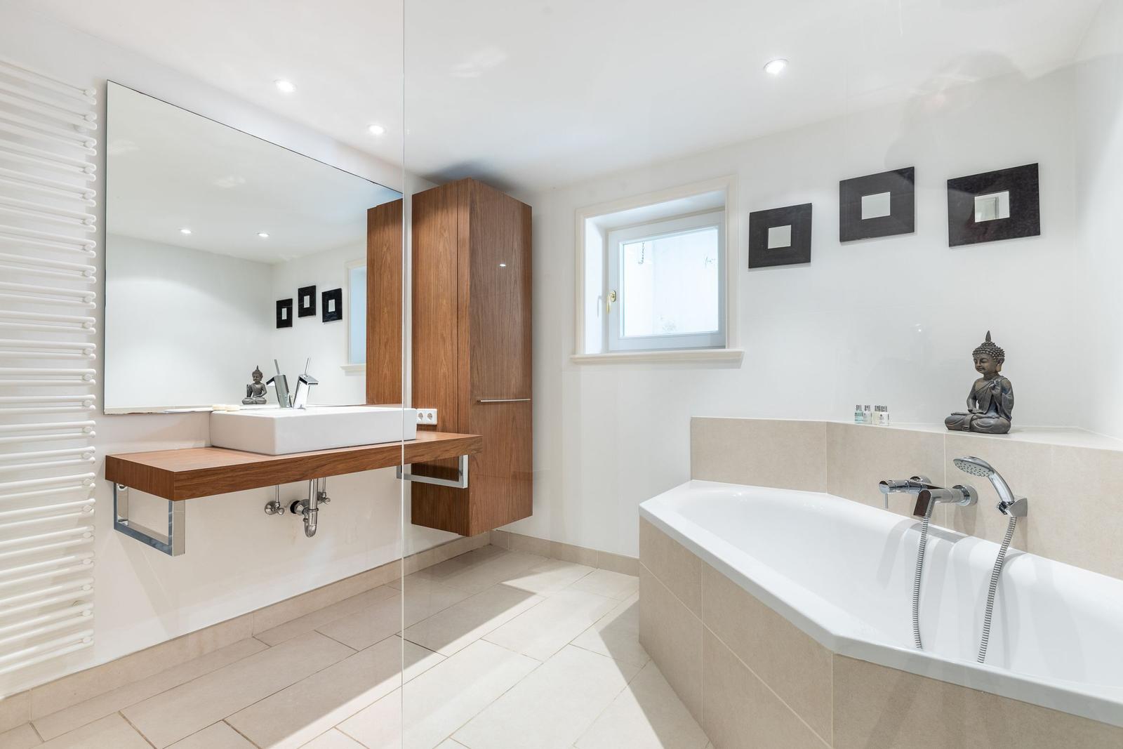 Badezimmer mit Badewanne, Waschbecken und Spiegel